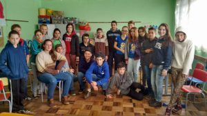 Foto das acadêmicas Jaqueline de Moura e Aloma Hancke com os alunos com os alunos do 8º e 9º da Escola Municipal Juscelino Kubitschek.